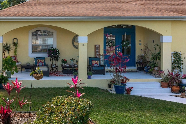 view of exterior entry featuring stucco siding and roof with shingles