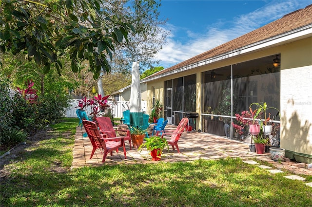 view of yard featuring a patio, fence, and a sunroom