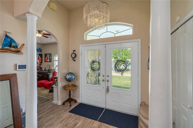 foyer with arched walkways, french doors, baseboards, and wood finished floors