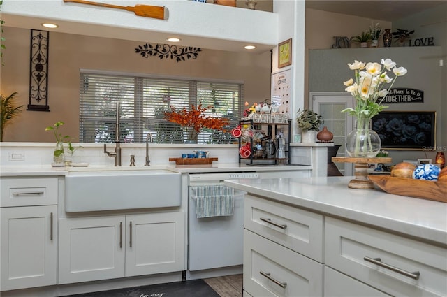 kitchen featuring a sink, white cabinetry, light countertops, and white dishwasher