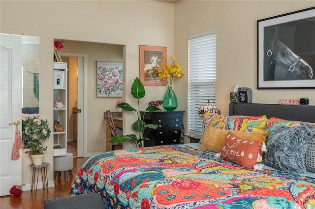 bedroom featuring baseboards and wood finished floors