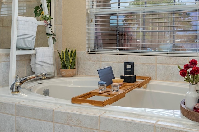 bathroom with a garden tub and a textured wall