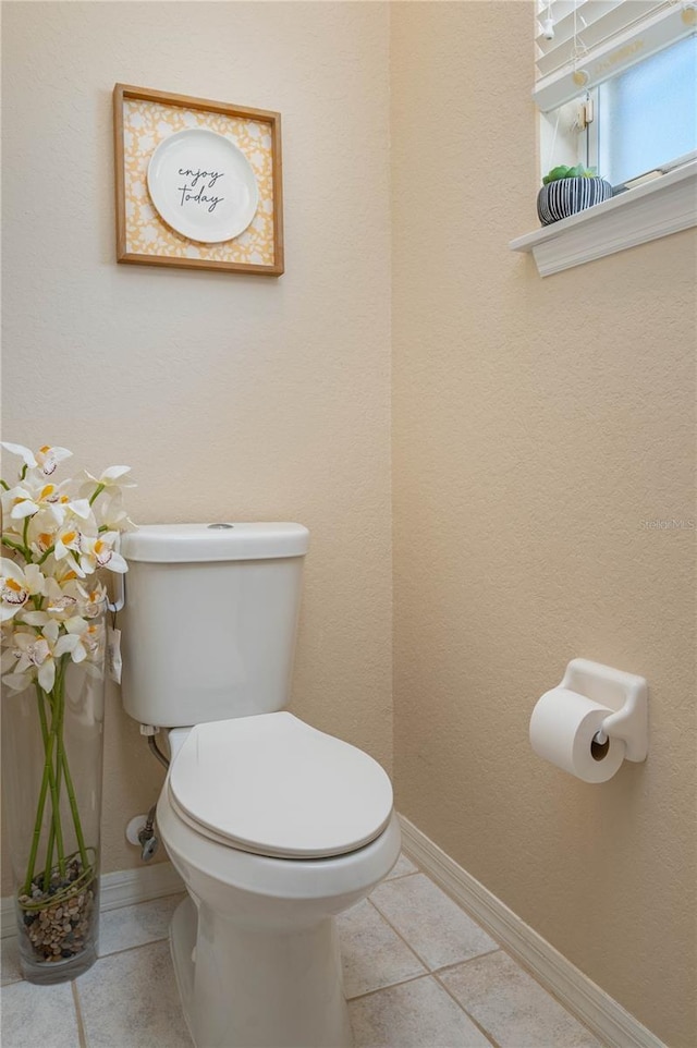 bathroom with tile patterned floors, toilet, and baseboards