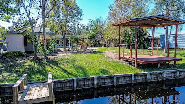 dock area with a lawn and a deck with water view