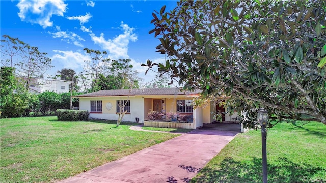 view of front of home with driveway, a front lawn, and stucco siding