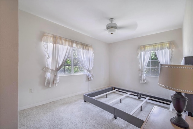 interior space featuring carpet, baseboards, and a ceiling fan