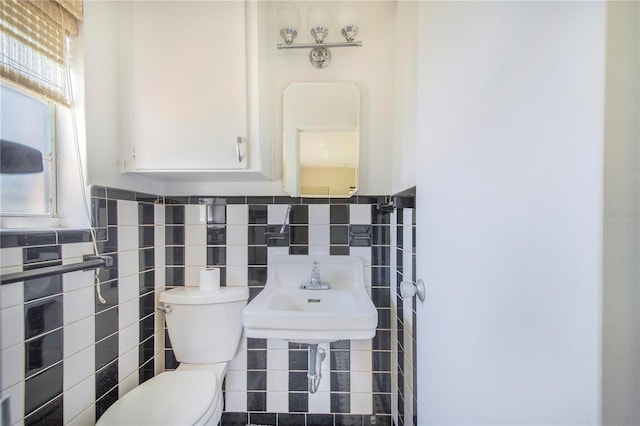 bathroom with toilet and tile walls