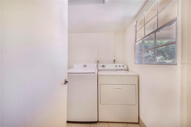 laundry area with laundry area, light tile patterned flooring, washing machine and clothes dryer, and attic access