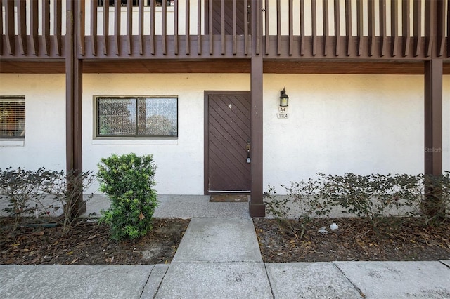 doorway to property featuring stucco siding