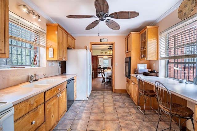 kitchen with tile patterned flooring, a sink, crown molding, and black appliances