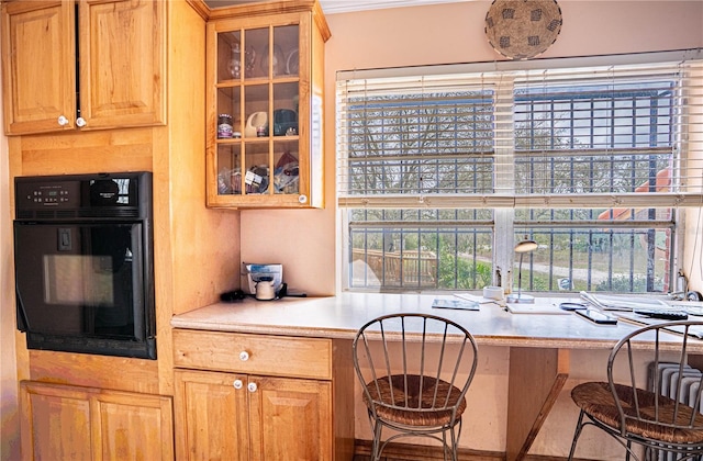 kitchen with glass insert cabinets, light countertops, and oven