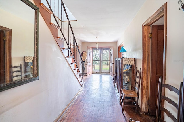 corridor with wood-type flooring and stairway