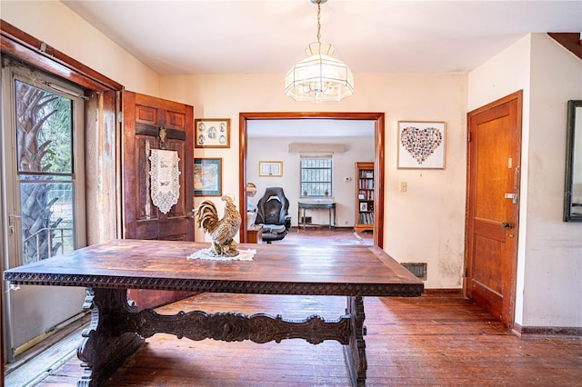 dining area with wood-type flooring, visible vents, and baseboards