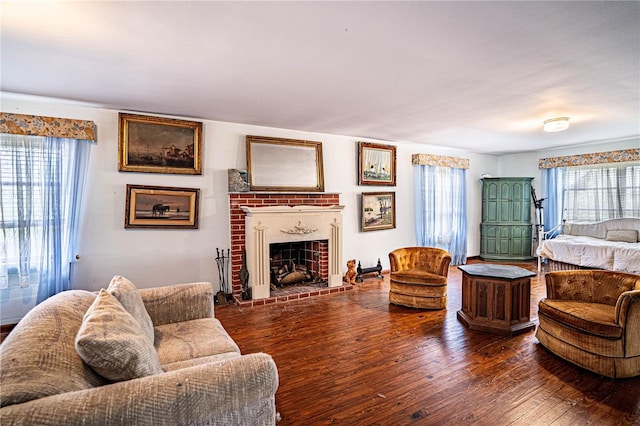 living room featuring a brick fireplace and wood-type flooring