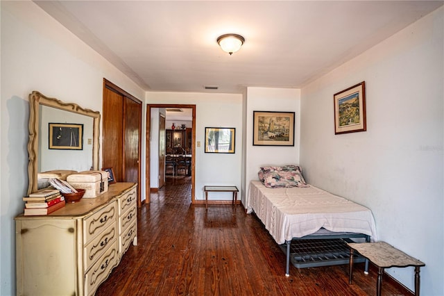 bedroom with visible vents, baseboards, and dark wood-style flooring
