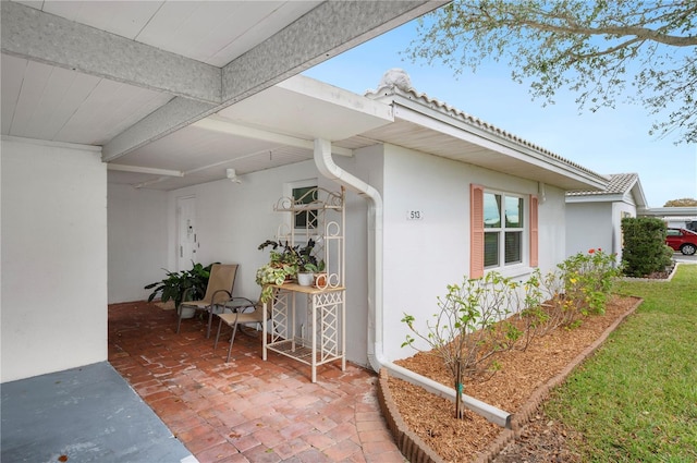 property entrance with a patio and stucco siding