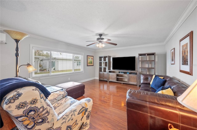 living room with a textured ceiling, wood finished floors, a ceiling fan, baseboards, and ornamental molding