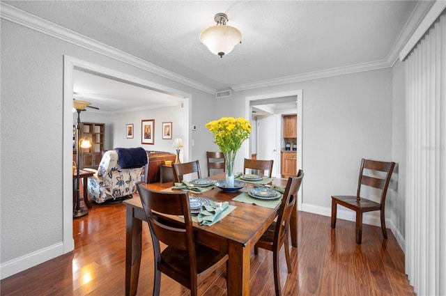 dining area with crown molding, a textured ceiling, baseboards, and dark wood-style flooring