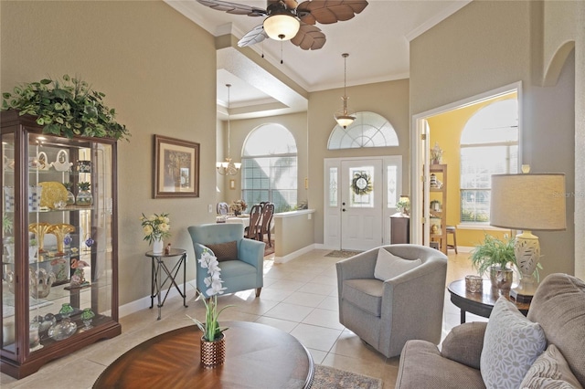 interior space with light tile patterned floors, ceiling fan, ornamental molding, and baseboards