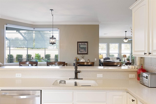 kitchen featuring a sink, ornamental molding, light countertops, and dishwasher