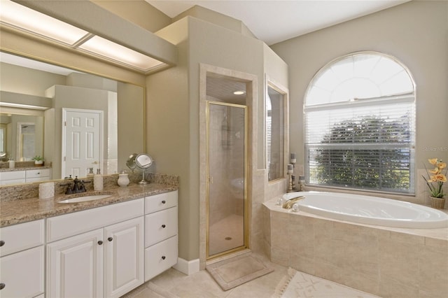 bathroom featuring a garden tub, a shower stall, tile patterned flooring, and vanity