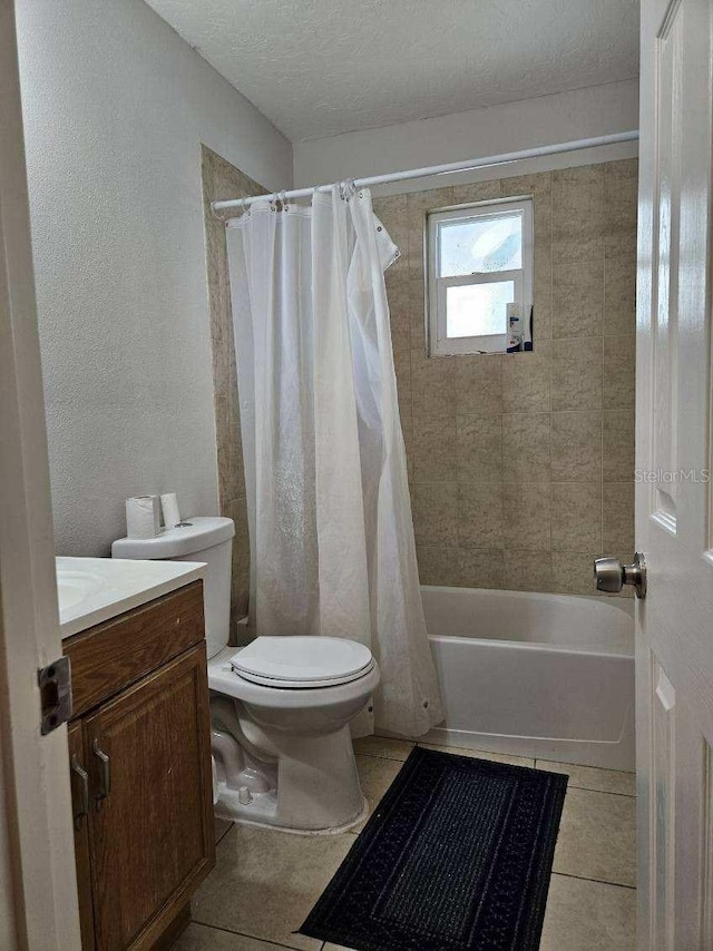 full bath featuring vanity, shower / bath combination with curtain, a textured ceiling, tile patterned floors, and toilet