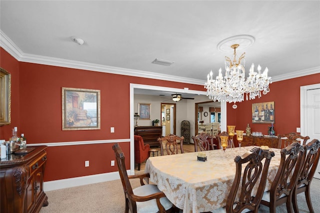 carpeted dining space with baseboards, ceiling fan with notable chandelier, visible vents, and crown molding