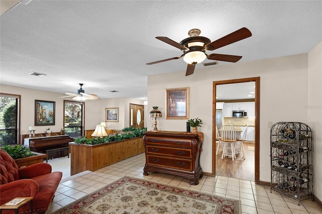 interior space featuring visible vents, a textured ceiling, and light tile patterned flooring