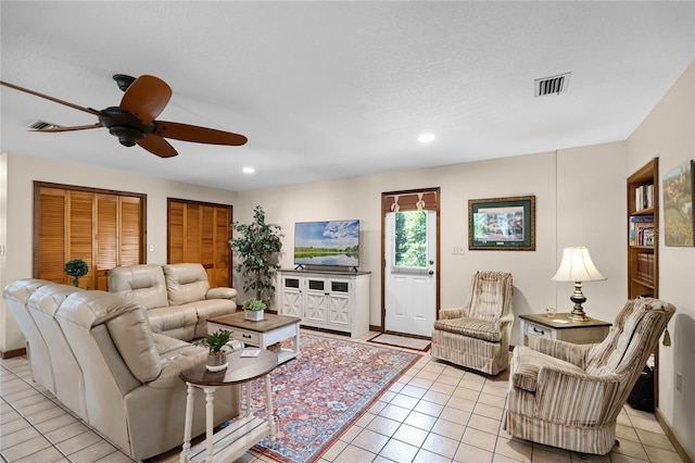 living room featuring baseboards, light tile patterned flooring, visible vents, and recessed lighting