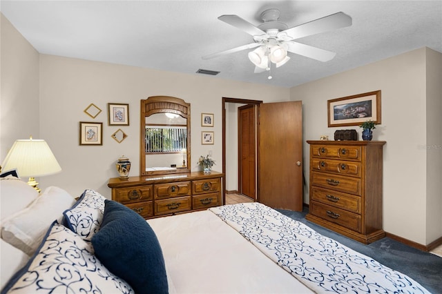 carpeted bedroom with a ceiling fan, visible vents, and baseboards