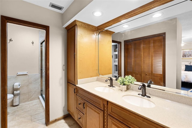 bathroom with toilet, a stall shower, visible vents, and a sink