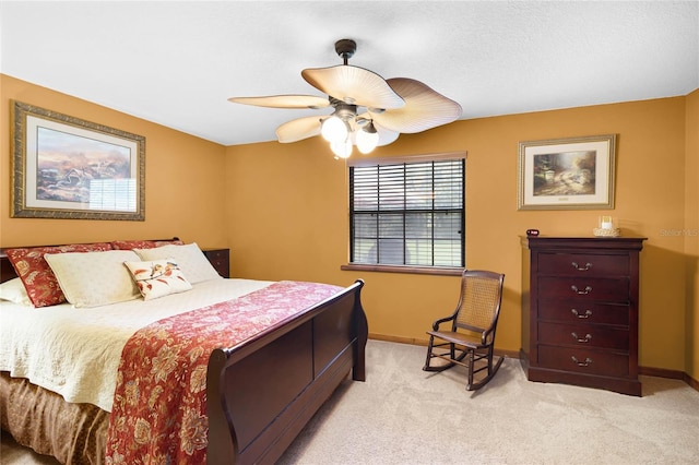 bedroom featuring a ceiling fan, light carpet, and baseboards