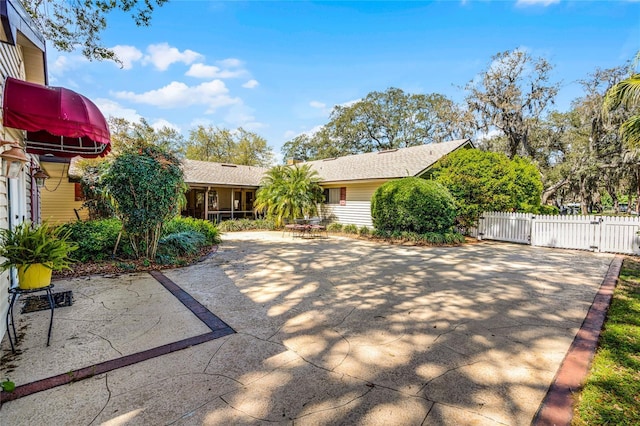 view of front of home featuring a patio, fence, and a gate