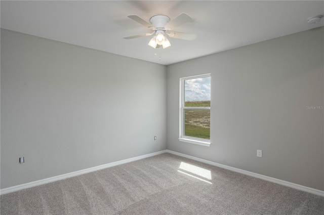 spare room with ceiling fan, carpet, and baseboards