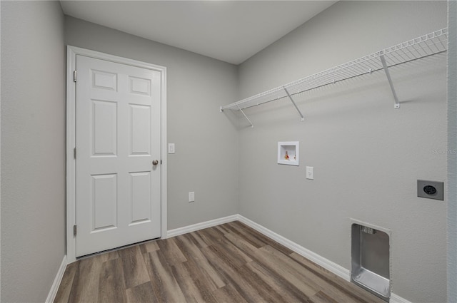 clothes washing area with hookup for a washing machine, hookup for an electric dryer, wood finished floors, laundry area, and baseboards