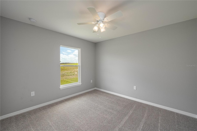 carpeted empty room featuring a ceiling fan and baseboards