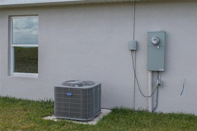 exterior details featuring central AC unit and stucco siding