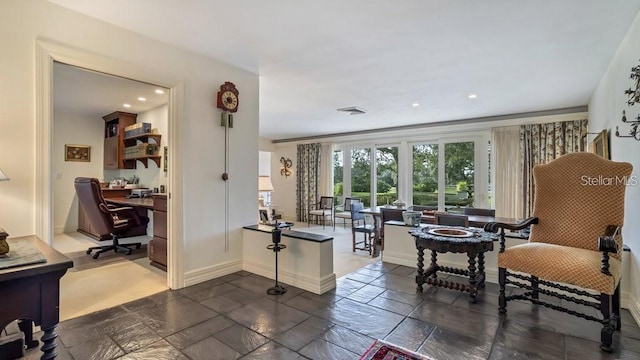 sitting room featuring built in desk, stone tile floors, recessed lighting, visible vents, and baseboards