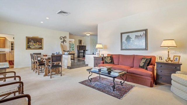 living area with recessed lighting, visible vents, and light colored carpet