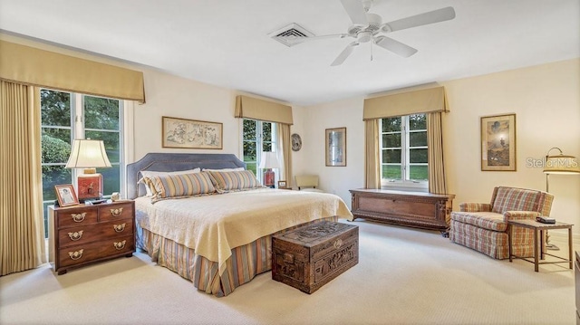 carpeted bedroom with multiple windows and a ceiling fan