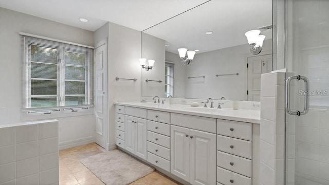 bathroom with double vanity, tile patterned flooring, a tile shower, and a sink