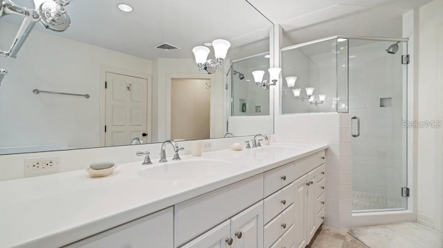 full bathroom featuring a stall shower, visible vents, a sink, and double vanity