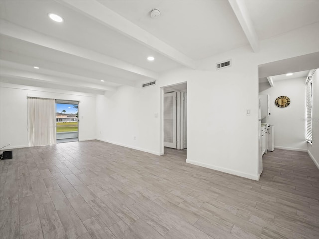 unfurnished living room with baseboards, visible vents, beamed ceiling, and wood finished floors