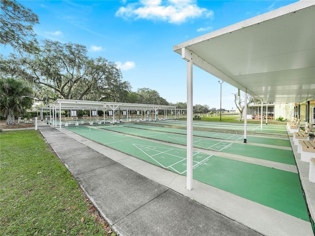 view of home's community featuring shuffleboard and a yard