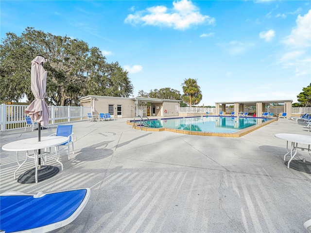 pool featuring fence and a patio