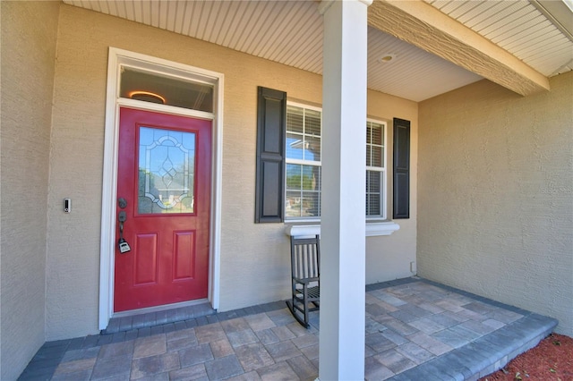 property entrance featuring stucco siding and a porch