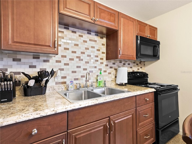 kitchen with black appliances, tasteful backsplash, brown cabinetry, and a sink