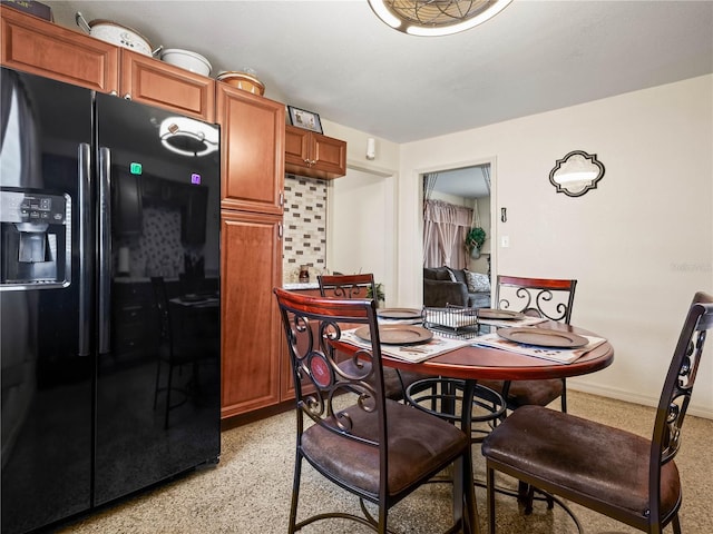 dining area with baseboards and light speckled floor