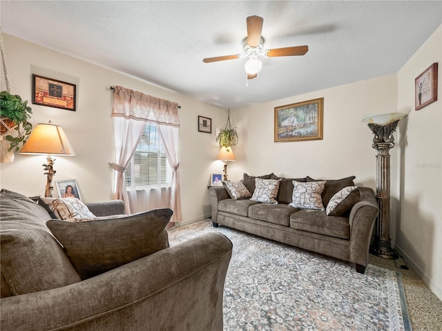 carpeted living area featuring a textured ceiling, ceiling fan, and baseboards