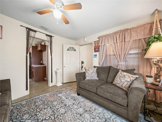 living area with ceiling fan, visible vents, and baseboards